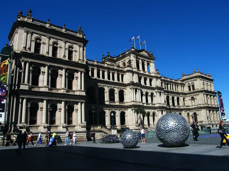 The sandstone heritage Treasury Building in Brisbane with steel sphere sculptures in the forecourt