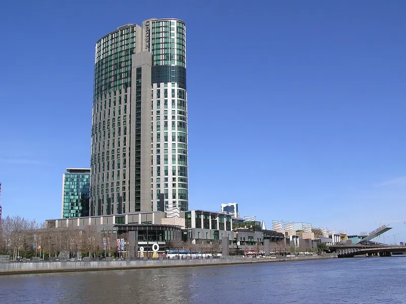 Crown Towers hotel and the Crown casino complex on the south bank of the Yarra River under a blue sky
